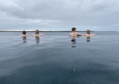 People enjoying the ocean view while bathing in the warm geothermal Sky Lagoon spa